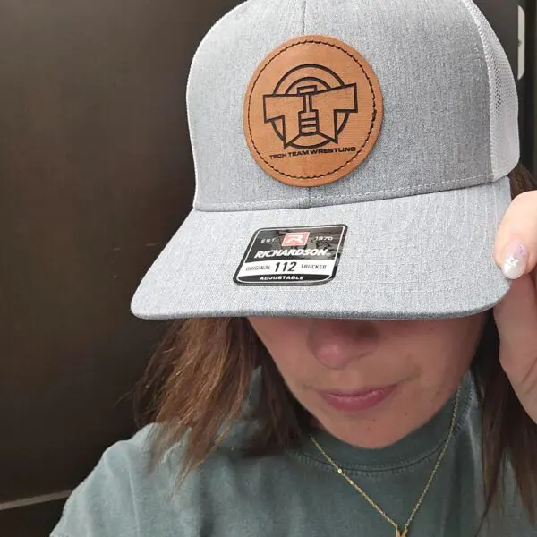 A woman wearing a hat with a leather patch on it.