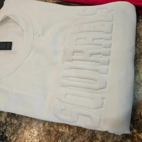 A white shirt with the word " courage " on it.