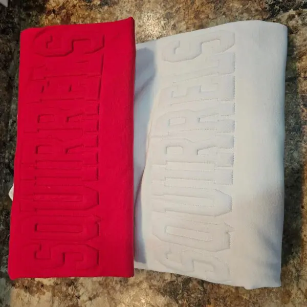 A red and white pillow with the word " support " on it.