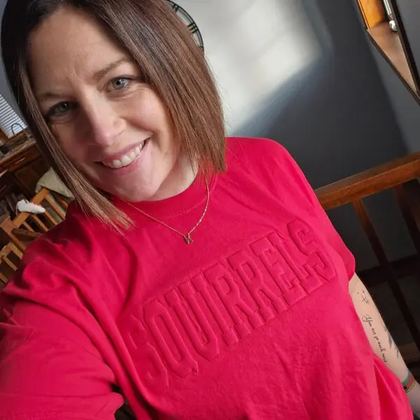 A woman in red shirt smiling for the camera.