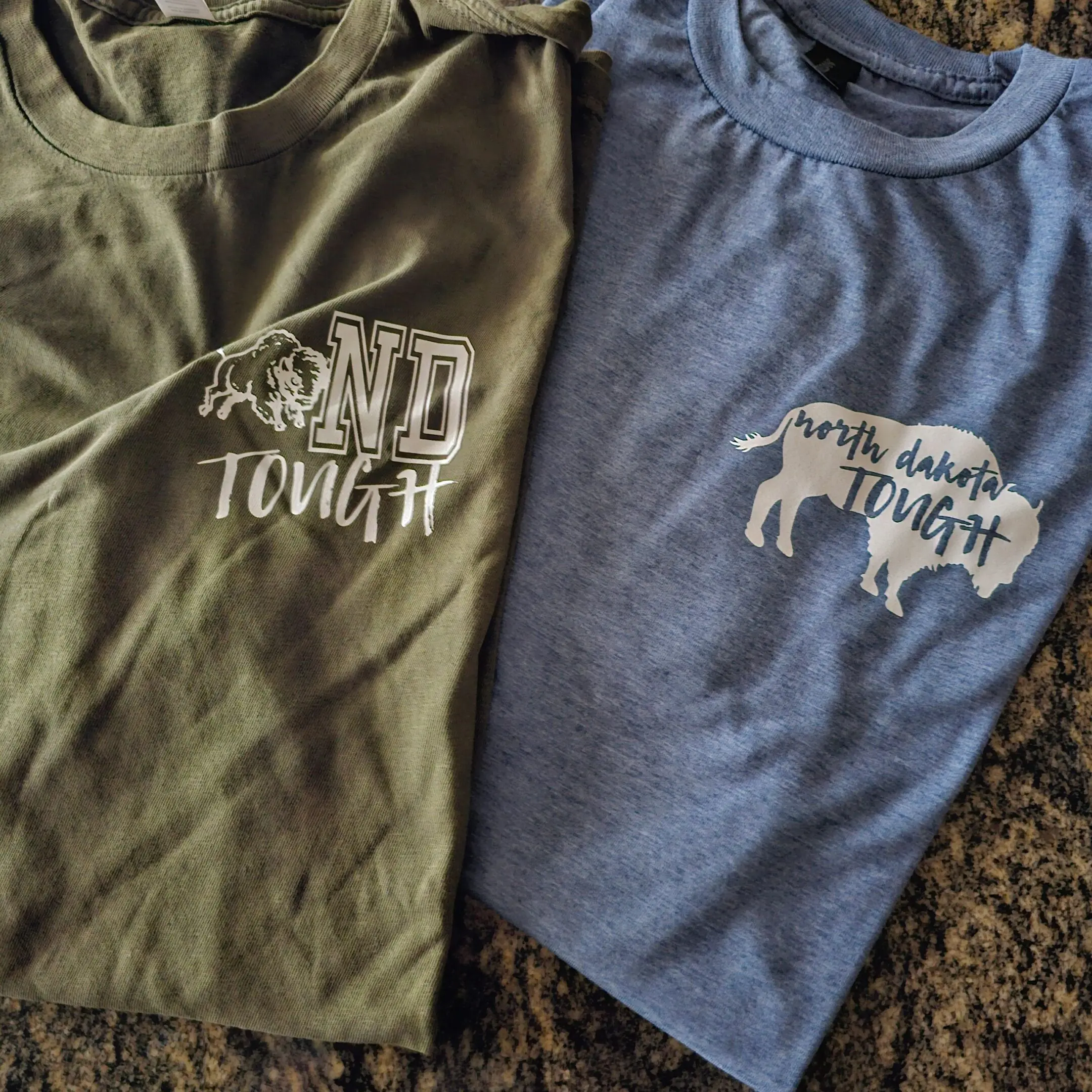 Two shirts that are sitting on a table.
