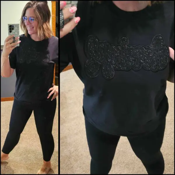A woman in black shirt and leggings taking selfie.