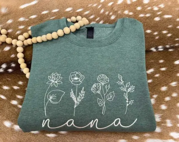 A green shirt with flowers and the word nana on it.
