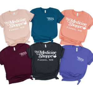 A group of different colored shirts with the words " medicine shoppe fargo, nd ".