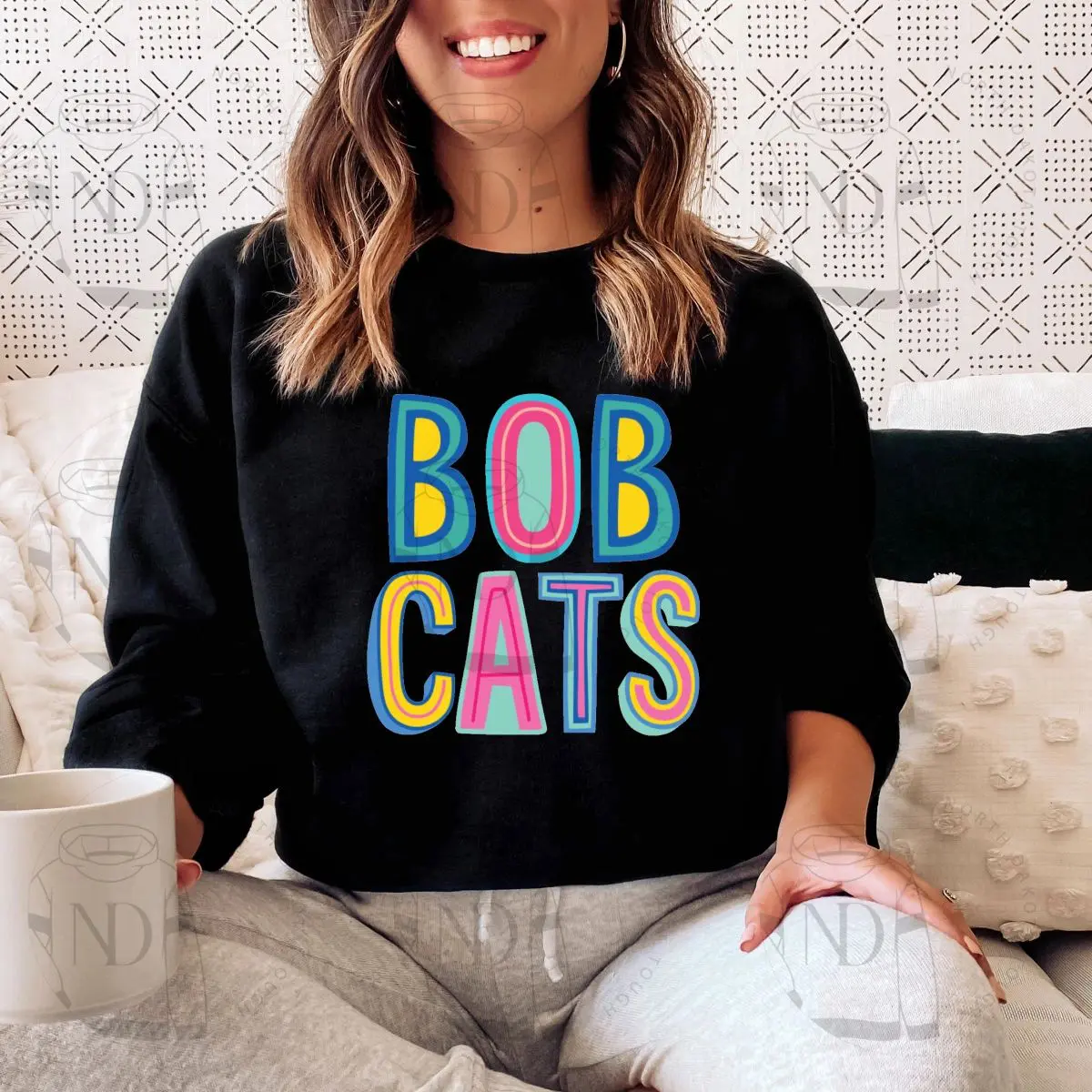 A woman sitting on the couch holding her cat.