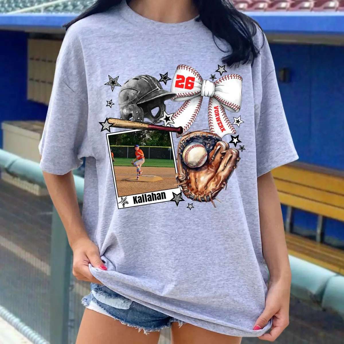 A woman wearing a gray t-shirt with baseball pictures on it.