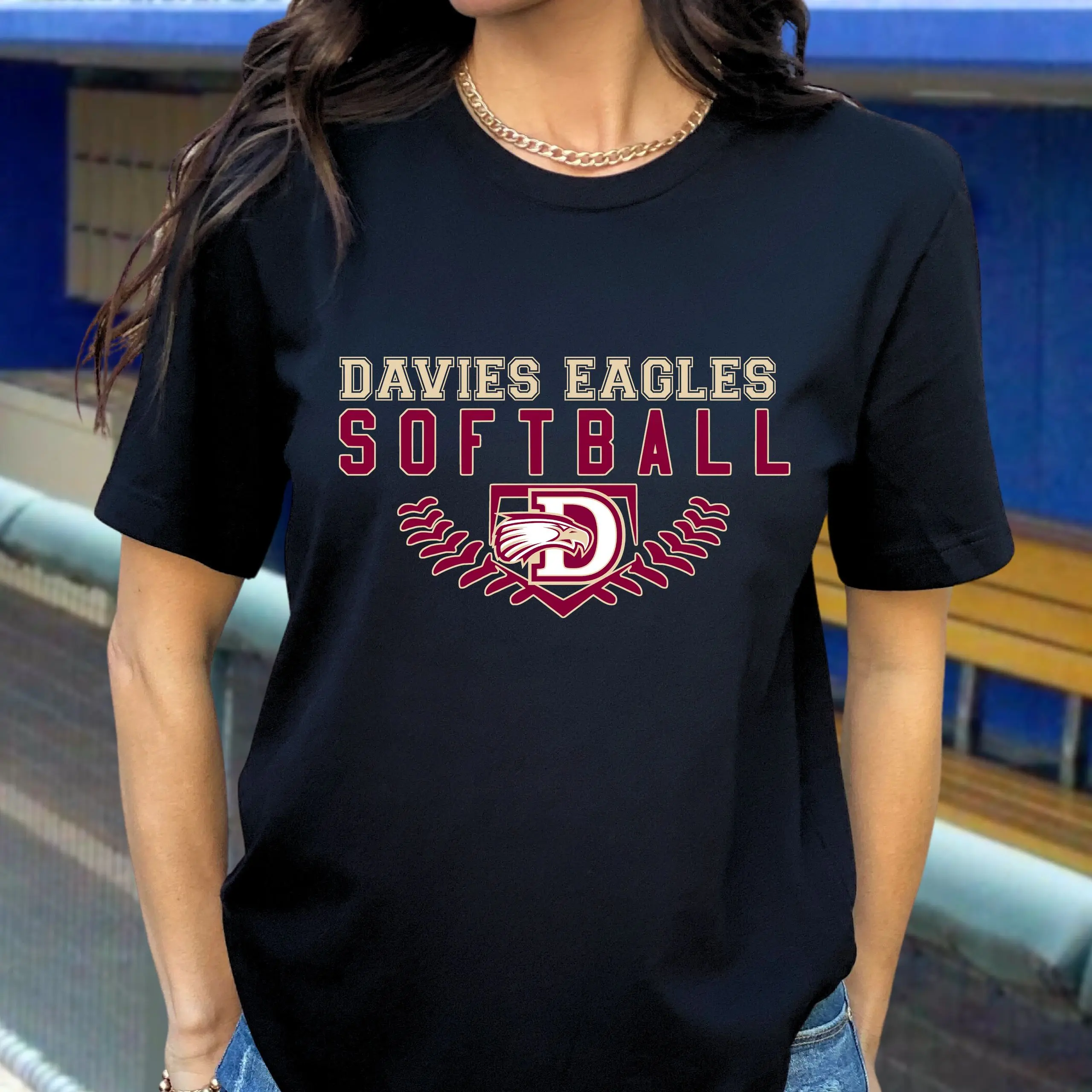 A woman wearing a black shirt with the words " davies eagles softball ".