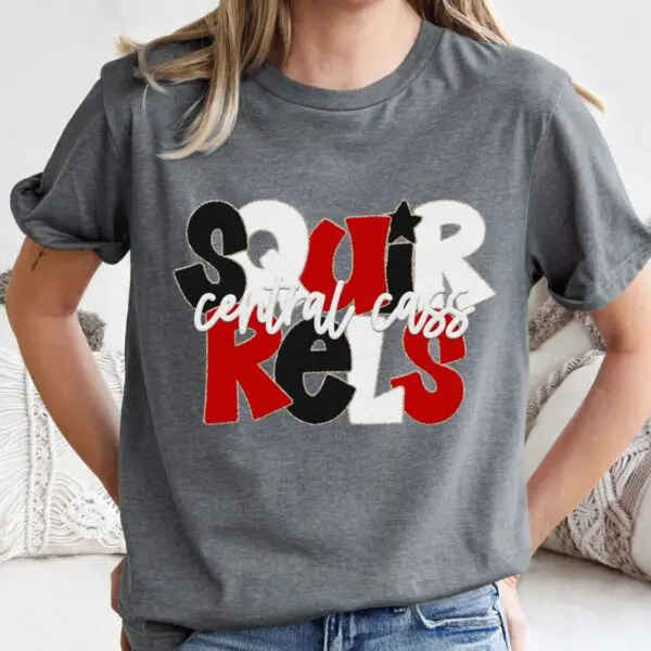 A woman wearing a gray t-shirt with the words " spirals central coast ".