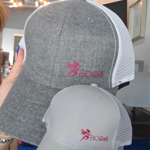 Two hats with a person holding them up.