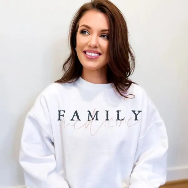 A woman wearing a white sweatshirt with the word family written on it.