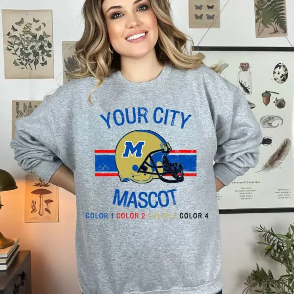 A woman standing in front of a wall with a sweatshirt.
