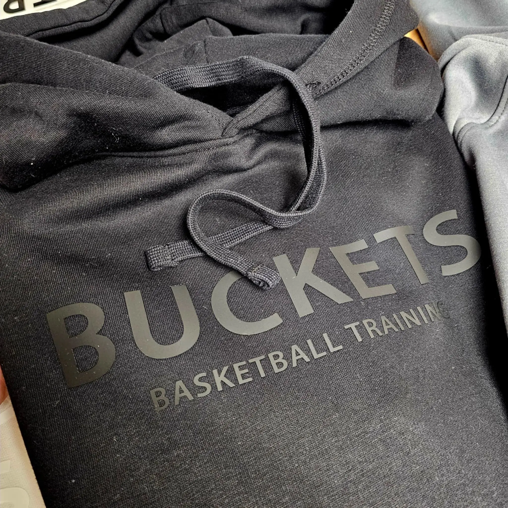 A close up of a hoodie with the word buckets on it