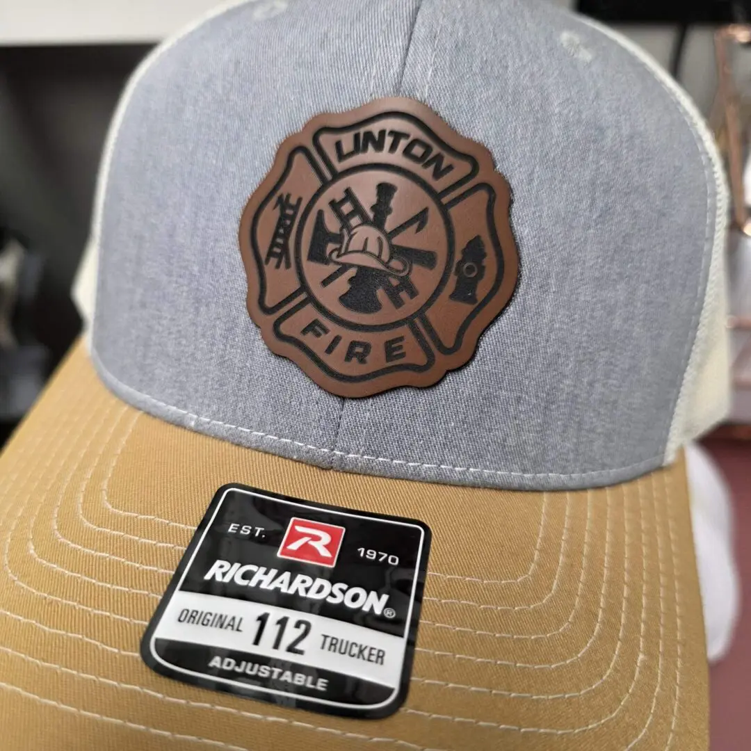 Gray and tan cap with fire department logo.