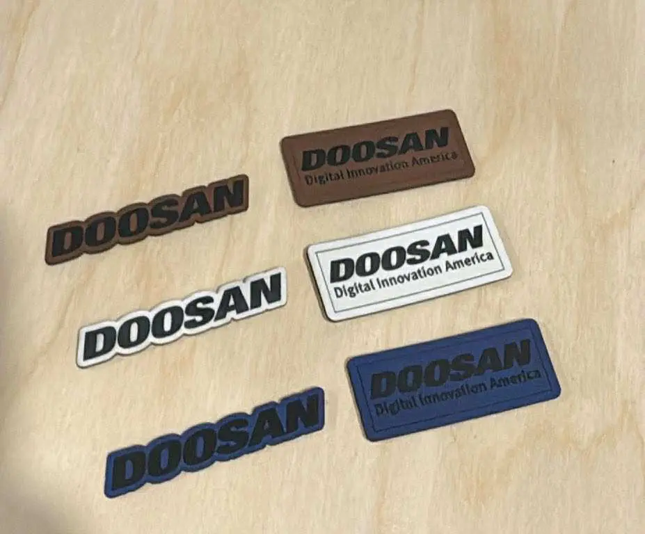 Assorted Doosan brand patches on wooden surface.