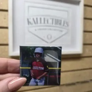 Hand holding youth baseball photo pin