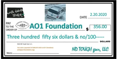 A donation check for an suv that is parked on the side of the road.