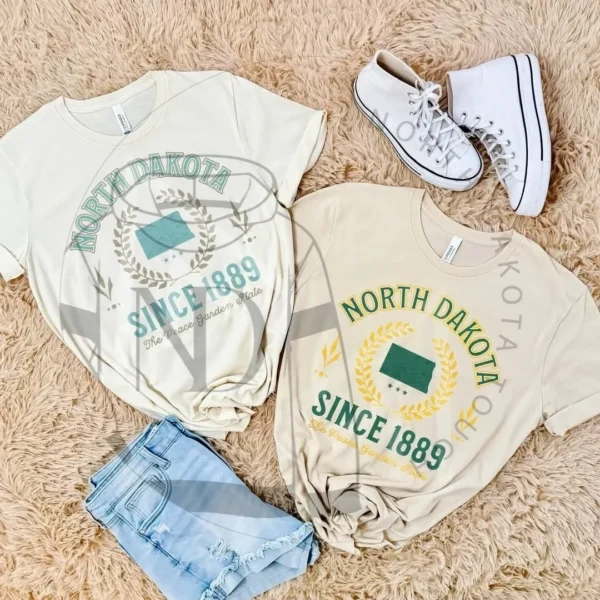A pair of white shoes and two t-shirts on the floor.