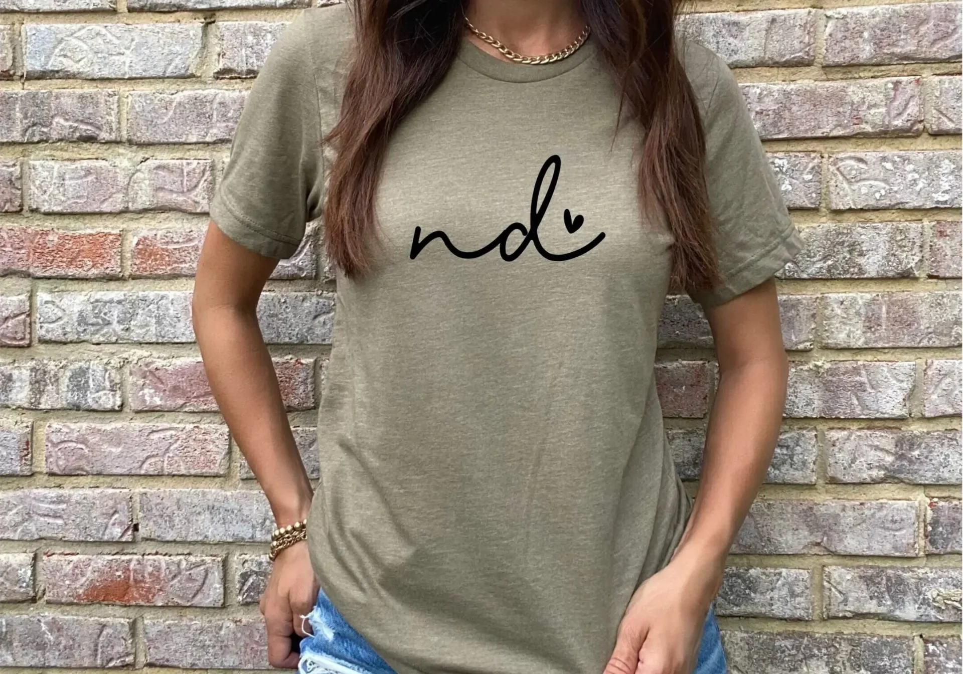 Woman in hat wearing green printed shirt.